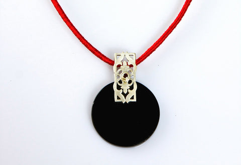 Beautiful, round black glass pendant with silver and garnet accent