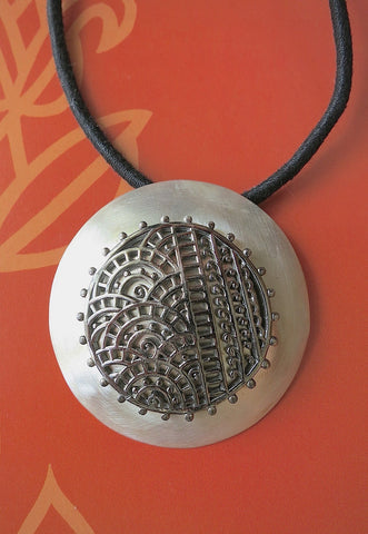 Dramatic, big round pendant with black rhodium plated mehndi-inspired center