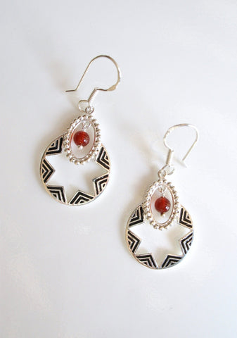 Quaint, oval dangling earrings with a garnet bead and fine black enamel work - Lai